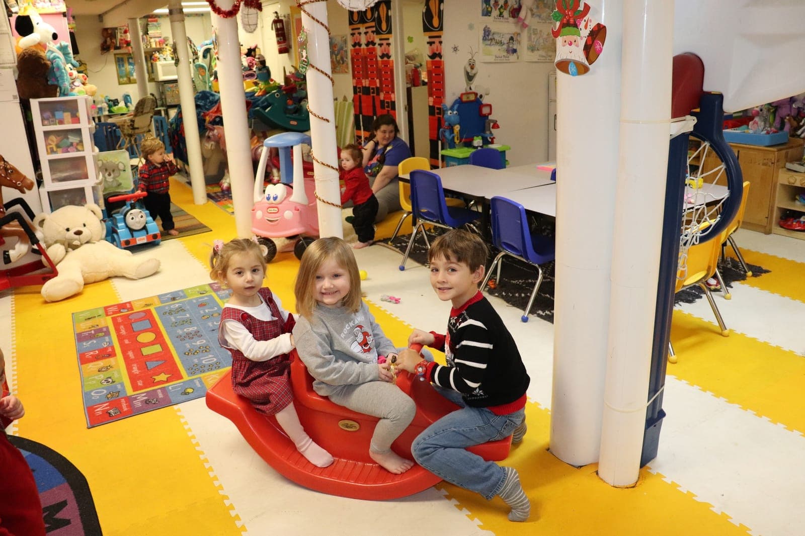 A group of toddlers playing together with a big bin of colorful wooden blocks