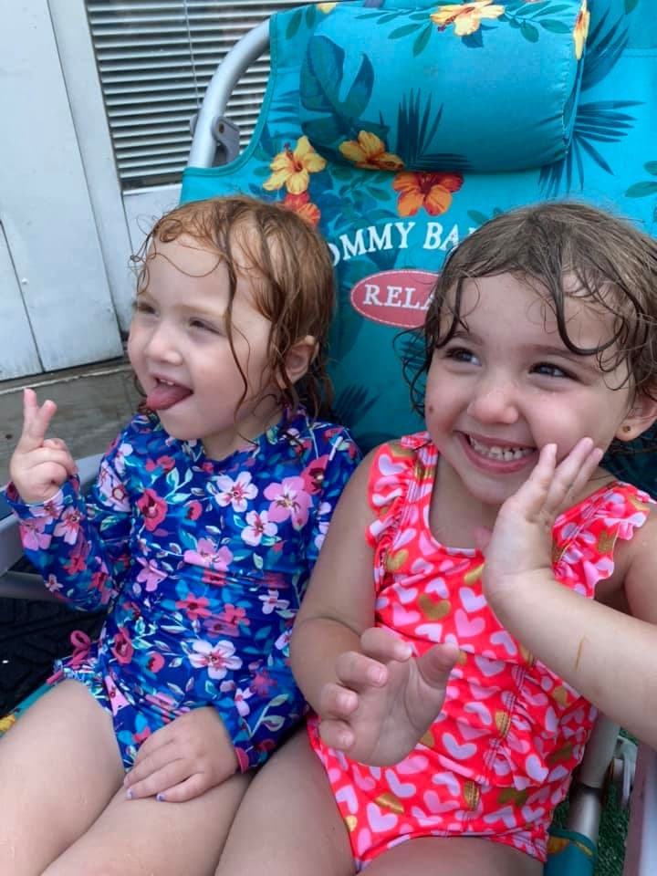 Two little friends sharing a sunny summer day by the pool