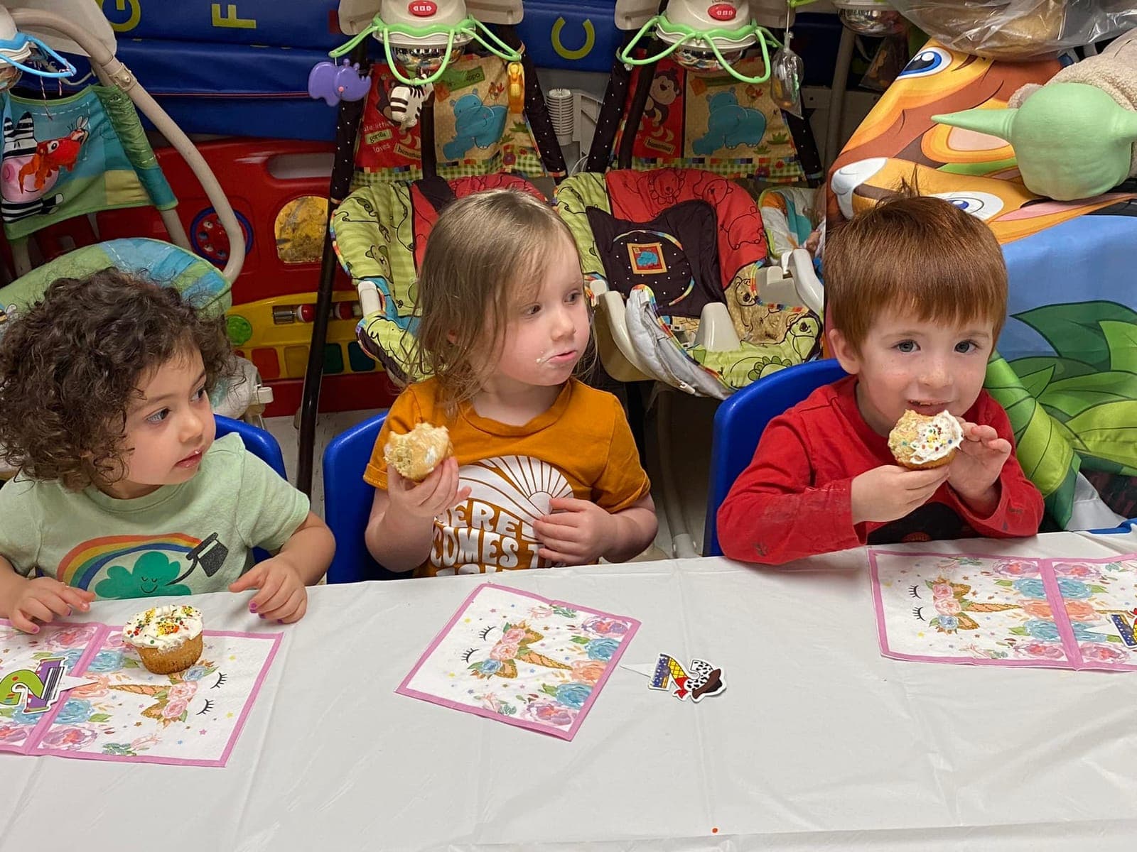Three kids enjoying cupcakes together at a little table at Kelly's Kidz Playhouse